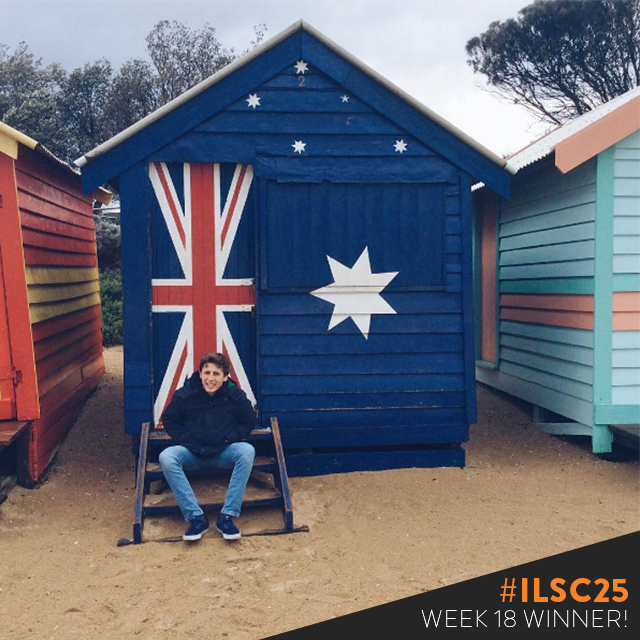 Ignacio seated in front of a cabin which has a painted Australian flag