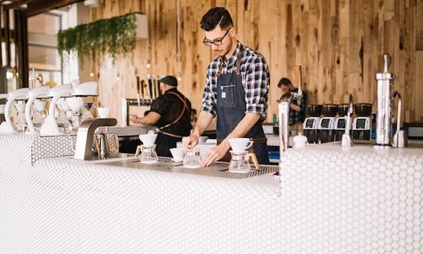 A barista making coffee as he works in a café.