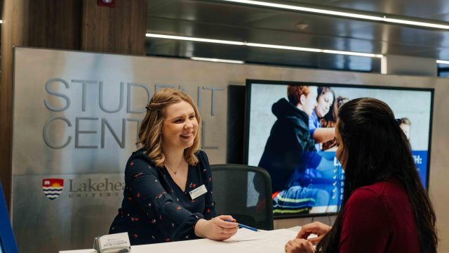 A Lakehead University Student Central staff member assisting a student.