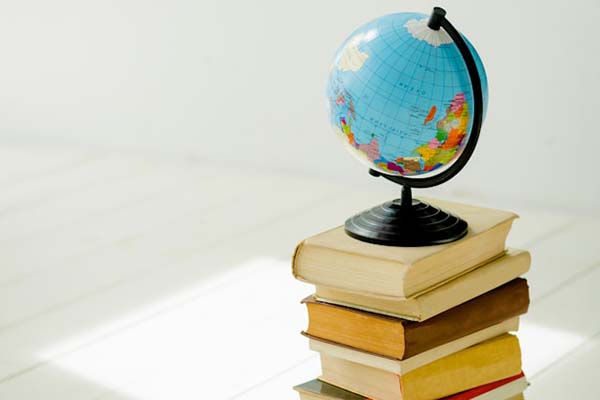 A world globe placed atop a stack of books.