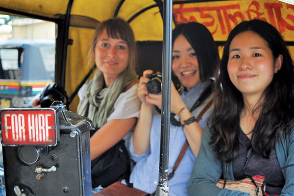 Three International students explore the city from a rickshaw while they study English in Delhi