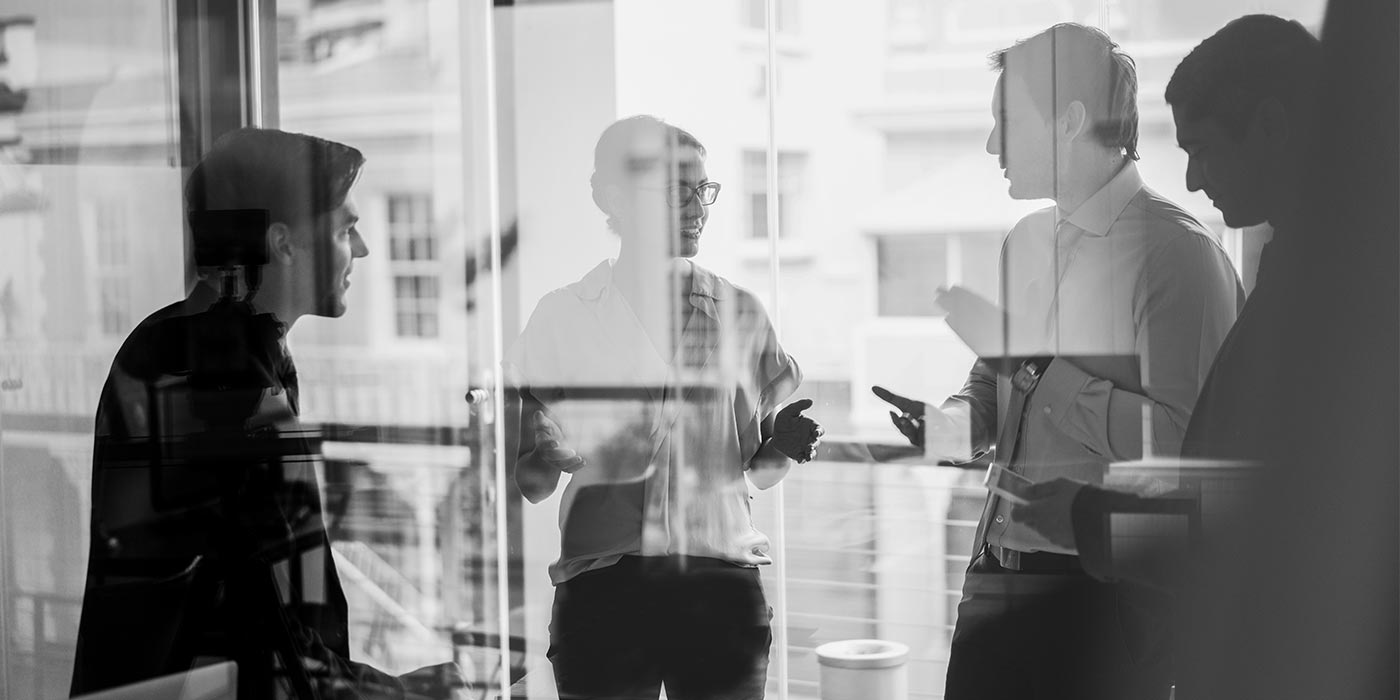 Group of business colleagues working in an office and discussing ideas - package multiple business VET programs for a long-term study program