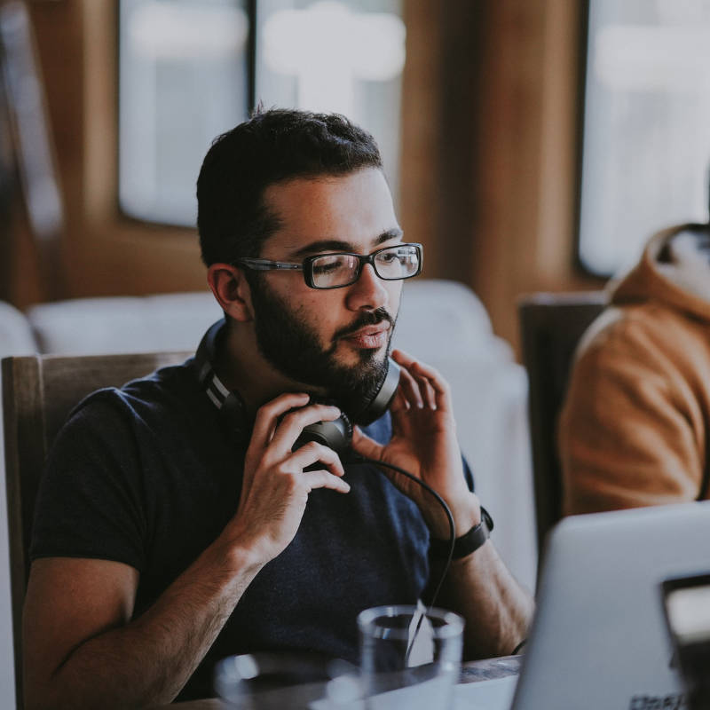 Young worker with headset in front of a laptop - why you should study marketing in Australia
