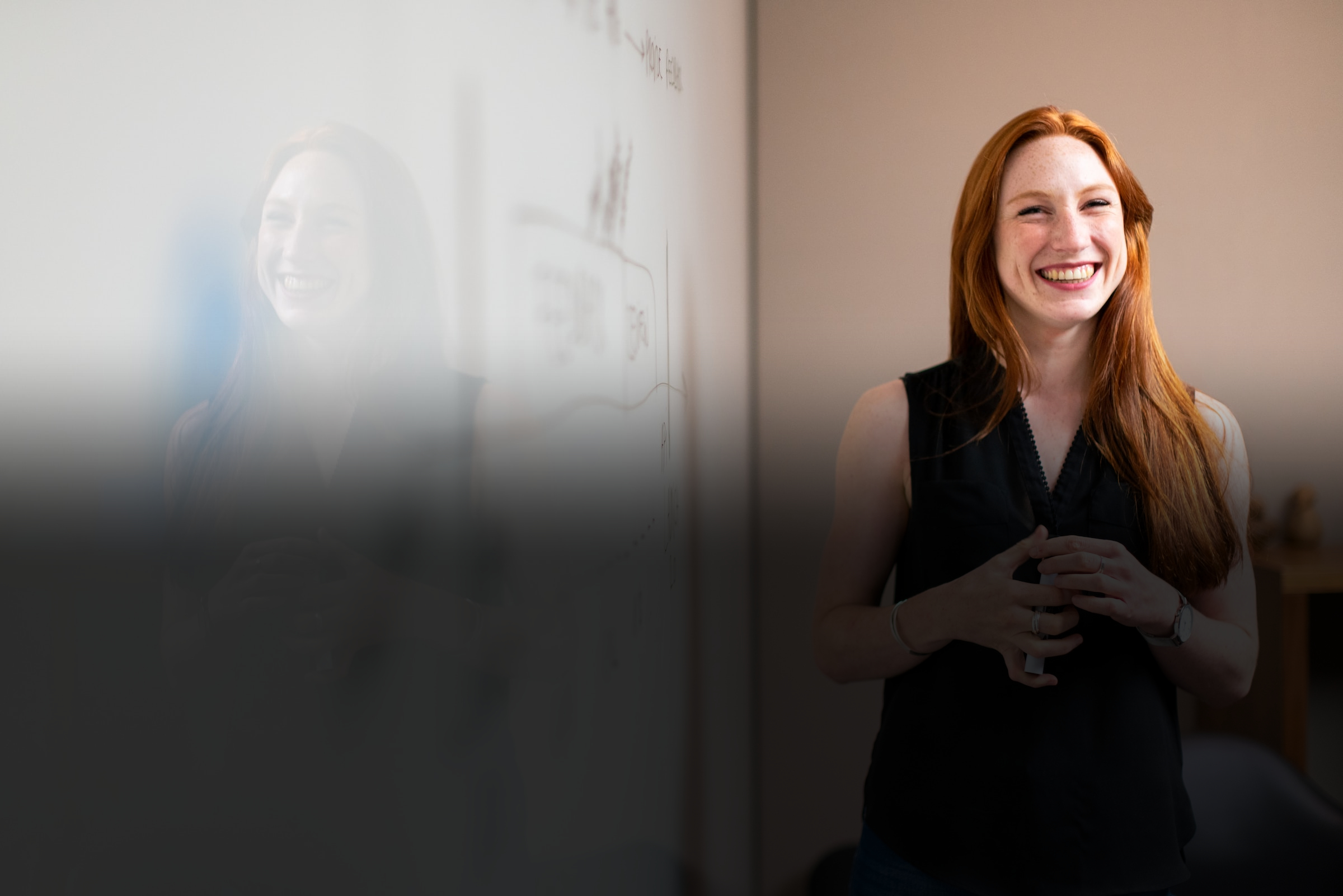 ILSC Australia Trinity College CertTESOL teacher smiling while standing next to a whiteboard 