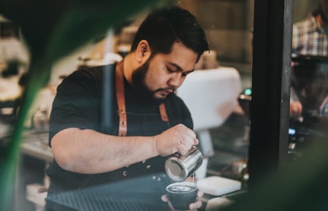 International student working in Canada as a barista in a local coffee shop. Study at Greystone College Canada and work off campus or take a co-op program.