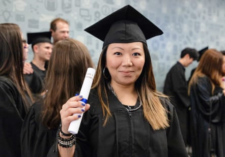 International student graduating from Greystone College holding diploma