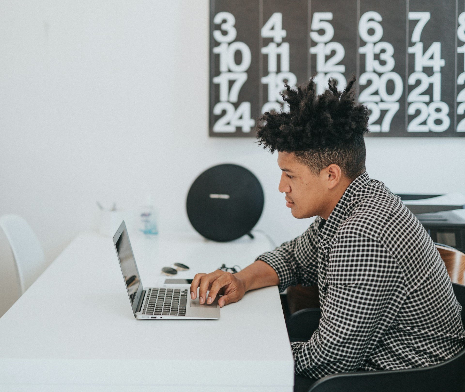 man-sitting-at-a-table-using-a-laptop