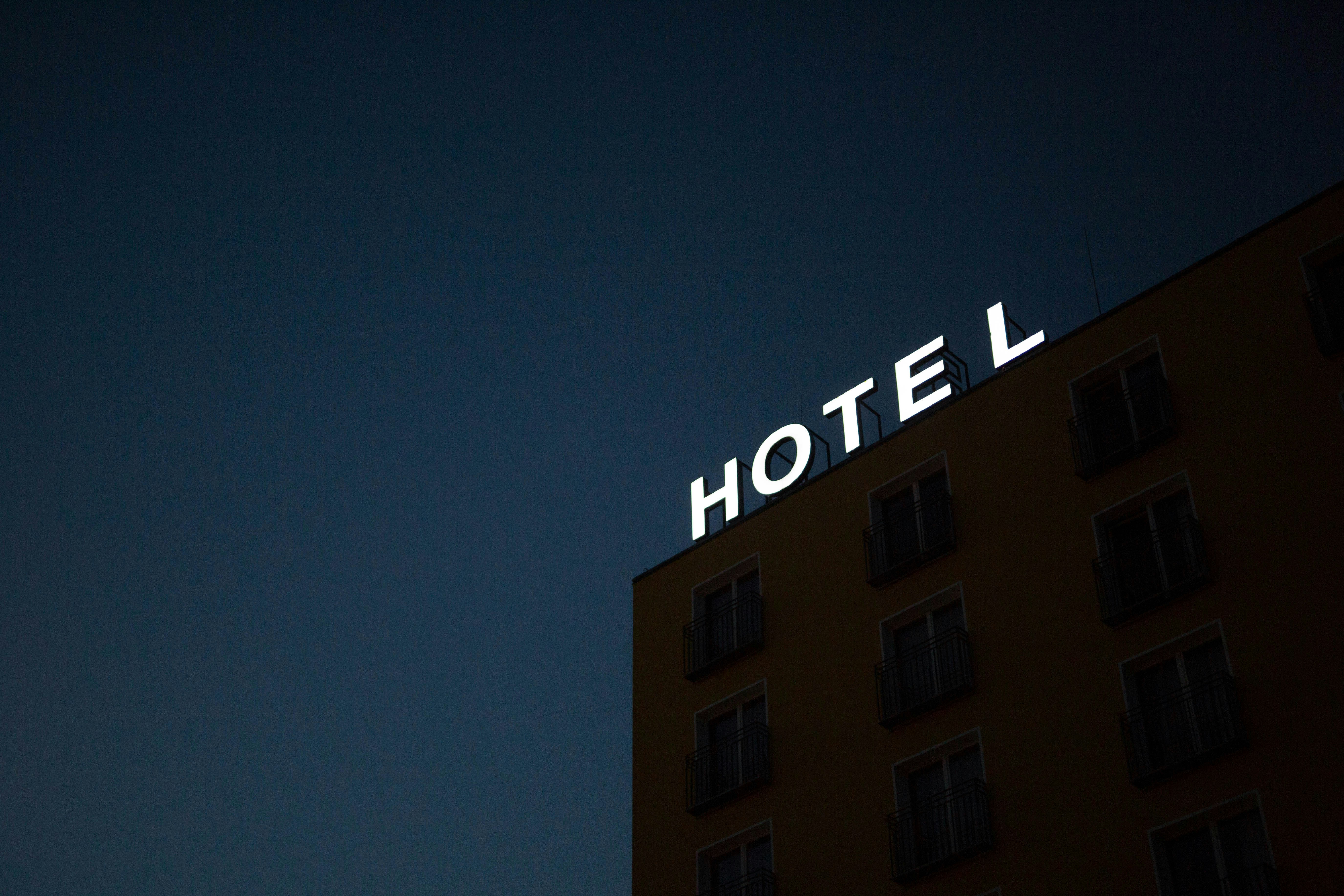 Dimly lit hotel building at dusk with glowing 